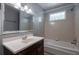 Cozy bathroom with a single sink vanity, bathtub and shower with a glass block window for natural light at 91 Rogers Se St, Atlanta, GA 30317
