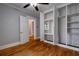 Bright bedroom featuring wood floors, a ceiling fan, and a built-in closet with shelves and drawers at 91 Rogers Se St, Atlanta, GA 30317
