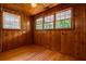 Rustic bedroom featuring wood paneling, hardwood floors, and windows overlooking the outdoors at 91 Rogers Se St, Atlanta, GA 30317