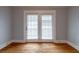Light-filled living room featuring hardwood floors and large French doors with blinds at 91 Rogers Se St, Atlanta, GA 30317