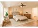 A bright bedroom with a ceiling fan, a beige bed with matching nightstands, and hardwood floors at 1282 Harris Commons Pl, Roswell, GA 30076