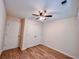 A cozy bedroom with wood floors, ceiling fan, and white closet doors at 1282 Harris Commons Pl, Roswell, GA 30076