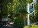 Entrance sign to Harris Commons neighborhood with lush greenery and a tree-lined road at 1282 Harris Commons Pl, Roswell, GA 30076