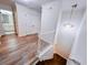 Hallway featuring wood-look flooring, white walls, stairs, and a view to the bathroom at 1282 Harris Commons Pl, Roswell, GA 30076