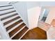 Staircase with dark wood treads, white risers, and a view to the bathroom at 1282 Harris Commons Pl, Roswell, GA 30076