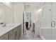 Bathroom featuring a modern shower with glass door, double sink vanity, and stylish tile flooring at 2076 Holtz Ln, Atlanta, GA 30318