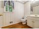Half bathroom featuring a toilet, vanity, mirror, and patterned wallpaper at 3420 Cranborne, Marietta, GA 30062