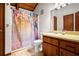 Bathroom with colorful floral shower curtain, light wood vanity and ample counter space at 3611 Winfair Pl, Marietta, GA 30062
