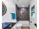 Modern bathroom with dark gray tiling in the shower, toilet, and a blue square sink vessel on granite countertop at 851 Flagler Se Cir, Smyrna, GA 30080