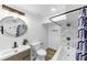 Bathroom featuring a granite-topped vanity, a large round mirror, and a tiled shower over tub at 851 Flagler Se Cir, Smyrna, GA 30080