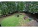 Aerial view of the backyard features a large grassy area, mature trees, and small shed at 131 Banyon Ct, Dallas, GA 30157
