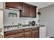 Basement wet bar featuring dark wood cabinets, granite countertop, sink, and beverage cooler at 131 Banyon Ct, Dallas, GA 30157