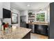 Bright kitchen with stainless steel appliances, granite countertops, floating shelves, and a view of the backyard at 2240 Cheshire Bridge Ne Rd # 206, Atlanta, GA 30324