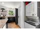 Kitchen featuring granite countertops, stainless steel appliances, floating shelves, and a stackable washer and dryer at 2240 Cheshire Bridge Ne Rd # 206, Atlanta, GA 30324