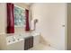 A relaxing soaking tub is featured in this bathroom with neutral paint and natural light at 2397 Cove Lake Rd, Lithonia, GA 30058