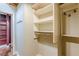 Walk-in closet with white shelving and a rack next to a room with red painted walls at 63 Mangum Sw St # 3, Atlanta, GA 30313