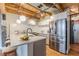 Modern kitchen with stainless steel appliances, white cabinetry, island counter, and exposed wood ceiling beams at 63 Mangum Sw St # 3, Atlanta, GA 30313