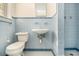 Tiled bathroom featuring blue tiling on the walls and floors, toilet, sink, and walk-in shower at 1206 Tuckawanna Sw Dr, Atlanta, GA 30311