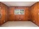 Bedroom with wood-paneled walls, carpet flooring, and a window providing natural light and a view of the outside at 1206 Tuckawanna Sw Dr, Atlanta, GA 30311