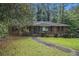 Charming brick home with a landscaped front yard, mature trees, and a paved walkway leading to the front door at 1206 Tuckawanna Sw Dr, Atlanta, GA 30311