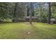 A wide shot of this brick home with a well-manicured front lawn, mature trees, and partial shade at 1206 Tuckawanna Sw Dr, Atlanta, GA 30311