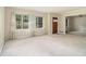 Neutral living room featuring plush carpeting, three large windows with sheer curtains, and a view into an adjacent space at 1206 Tuckawanna Sw Dr, Atlanta, GA 30311