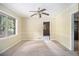 Living room with neutral paint, plush carpet, a ceiling fan, and a large window overlooking the front yard at 1206 Tuckawanna Sw Dr, Atlanta, GA 30311