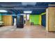 Open basement featuring wood-look flooring, storage cabinets, and black refrigerator at 2419 Anderson Mill Rd, Austell, GA 30106
