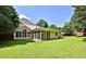Beautiful backyard with lush green grass, mature trees, and a screened-in porch at 3520 Mystic Dr, Buford, GA 30519