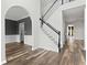 Bright entryway featuring wood floors, an elegant staircase, and neutral paint colors throughout at 3520 Mystic Dr, Buford, GA 30519