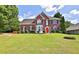Attractive two-story brick home with a well-maintained lawn and landscaping in a residential area at 3520 Mystic Dr, Buford, GA 30519