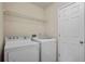 Cozy laundry room with a white washer and dryer with access door and wire shelving at 3520 Mystic Dr, Buford, GA 30519