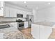 Bright kitchen boasts granite counters, stainless steel appliances, and sleek white cabinetry at 3660 Cattle Field Xing, Loganville, GA 30052