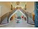 Grand foyer featuring a dual staircase with wrought iron railings and travertine flooring at 720 Heards Ferry Rd, Sandy Springs, GA 30328