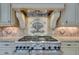 Close up shot of the range showing tile backsplash, custom vent hood, and stone countertops for easy meal preparation at 720 Heards Ferry Rd, Sandy Springs, GA 30328