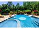 Swimming pool with water features and ample lounge seating surrounded by mature landscaping at 720 Heards Ferry Rd, Sandy Springs, GA 30328