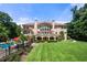 Expansive Mediterranean home with a large manicured lawn and covered outdoor living space at 720 Heards Ferry Rd, Sandy Springs, GA 30328