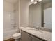 Bathroom featuring vanity with stone counter, framed mirror, tub with shower, and a neutral color palette at 1816 Kingsmere Run Dr, Loganville, GA 30052
