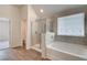 Modern bathroom with tiled shower, soaking tub, and wood-look flooring at 1816 Kingsmere Run Dr, Loganville, GA 30052