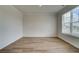 Bright, empty bedroom with wood-look flooring and large window providing natural light at 1816 Kingsmere Run Dr, Loganville, GA 30052