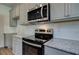The kitchen features stainless steel oven and microwave and granite countertops at 1816 Kingsmere Run Dr, Loganville, GA 30052