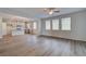 Open-concept living room features light-colored floors, natural light, and an adjacent modern kitchen with stainless appliances at 1816 Kingsmere Run Dr, Loganville, GA 30052