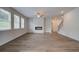 Open-concept living room with an electric fireplace, large windows, vinyl flooring, and easy access to other home areas at 1816 Kingsmere Run Dr, Loganville, GA 30052