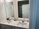 Bright bathroom featuring a double sink vanity and large mirrors reflecting the shower and a door at 2670 Greenbelt Rd, Snellville, GA 30078