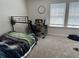 Carpeted bedroom with a metal-framed bed and desk setup by the window for studying at 2670 Greenbelt Rd, Snellville, GA 30078