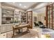 Comfortable home office with custom built-ins, wood desk, and view into adjacent seating area through french doors at 450 Dorset Sw Way, Smyrna, GA 30082