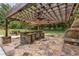 An outdoor kitchen featuring a stone island and stainless steel appliances at 450 Dorset Sw Way, Smyrna, GA 30082