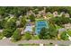 Community aerial view featuring a swimming pool, tennis courts, clubhouse, and tree-lined streets with residential homes at 11660 Windbrooke Way, Johns Creek, GA 30005