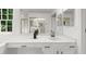 Bright bathroom with a white vanity, black hardware and dual mirrors at 11660 Windbrooke Way, Johns Creek, GA 30005
