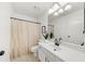 Bright bathroom with a single vanity, a mirror and a shower with a curtain at 11660 Windbrooke Way, Johns Creek, GA 30005